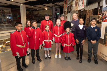 2.	Gyles Brandreth and Chelsea Pensioners Roy Palmer and Simon de Buisseret perform AA Milneâ€™s Buckingham Palace with pupils from Marlborough Primary School and Garden House School .